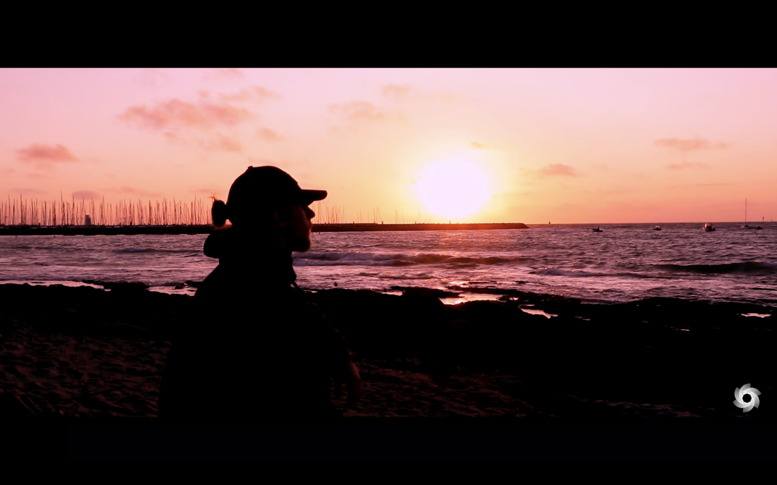 Photo de Louis assis face à la mer devant un coucher de soleil, extrait du projet “Je Vagabonde”.