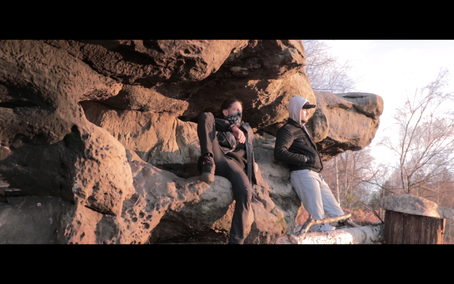 Photo de Louis alias Étoiles et son ami assis sur un rocher de forêt face au soleil, extrait du projet “Coming Home”.