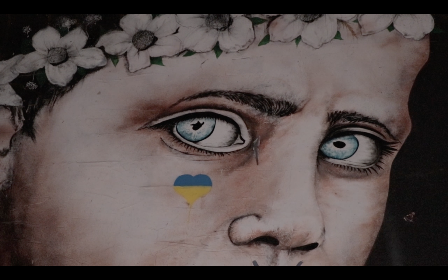 Graffiti représentant les yeux d’un petit garçon sur un mur.