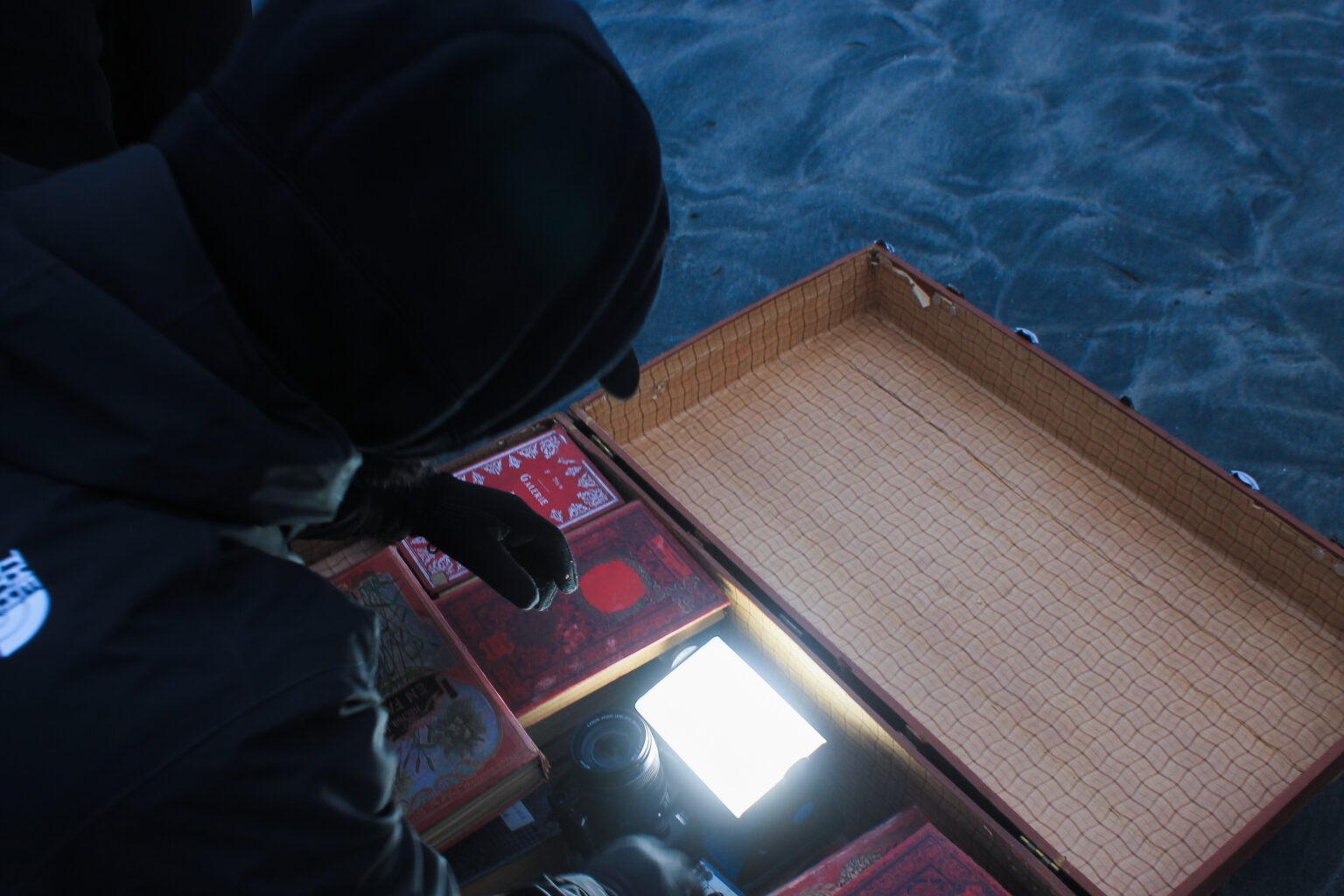 Louis Binisti alias Étoiles place une caméra dans un coffre, capturant un POV du coffre pendant que You Gee y cherche des livres.